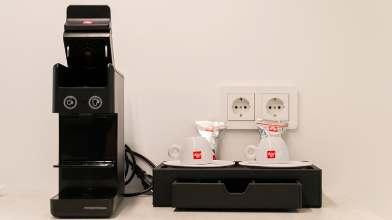 Illy brewer alongside branded mugs.
