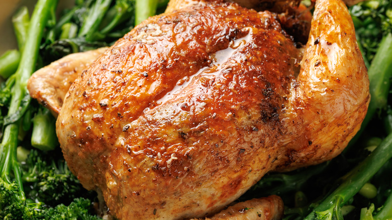 A rotisserie chicken on veggies.