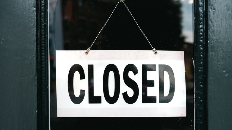 Closed sign hanging on glass door