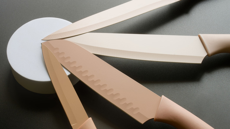 Closeup of a set of kitchen knives on a round whetstone
