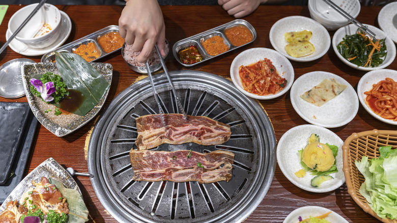 Traditional Korean BBQ round grill with side dishes called banchan