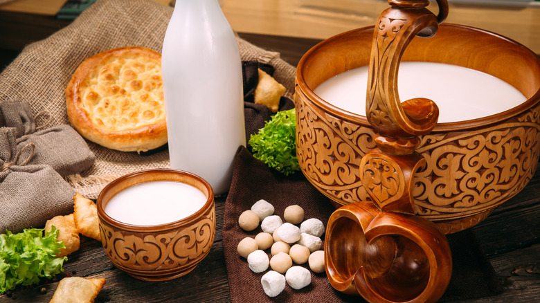 traditional spread of kumis milk in traditional bowl and cup surrounded by bread