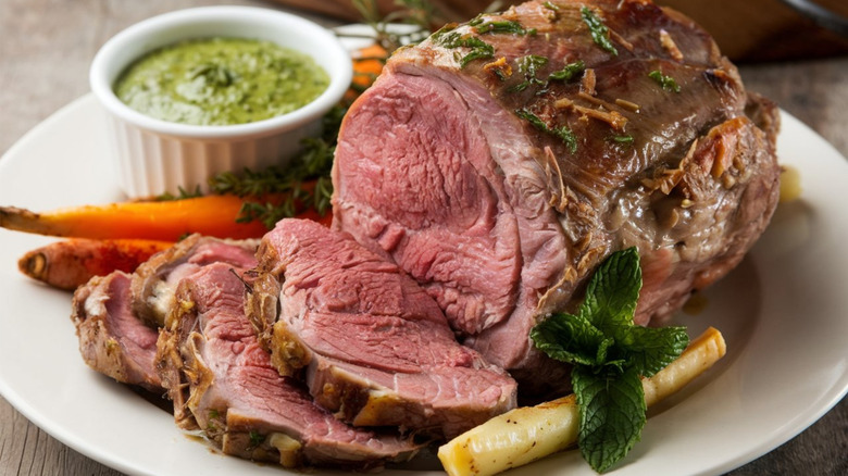 Sliced lamb roast served with mint sauce