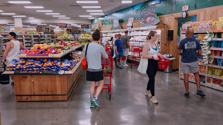Shoppers with carts and baskets mill around a Trader Joe's