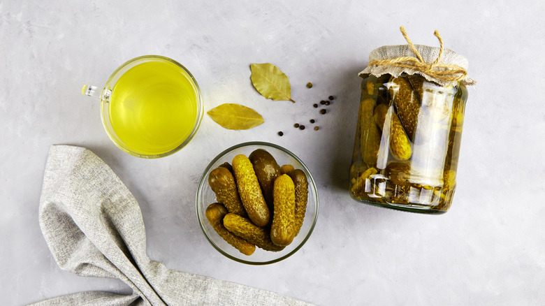 jar of pickles, bowl of pickles, measuring cup of pickle juice