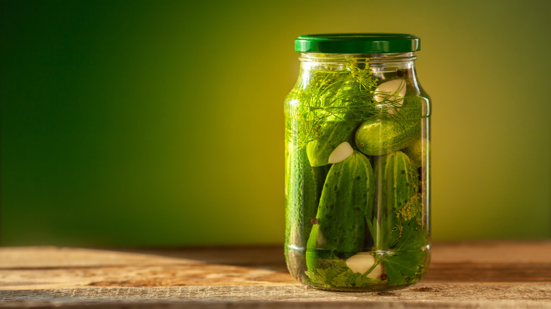 Jar of pickles against green background