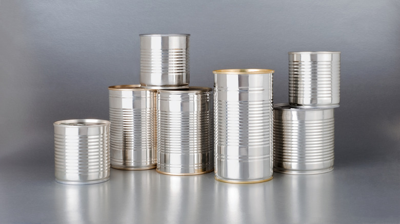 Aluminum cans with their labels removed sit against a gray background