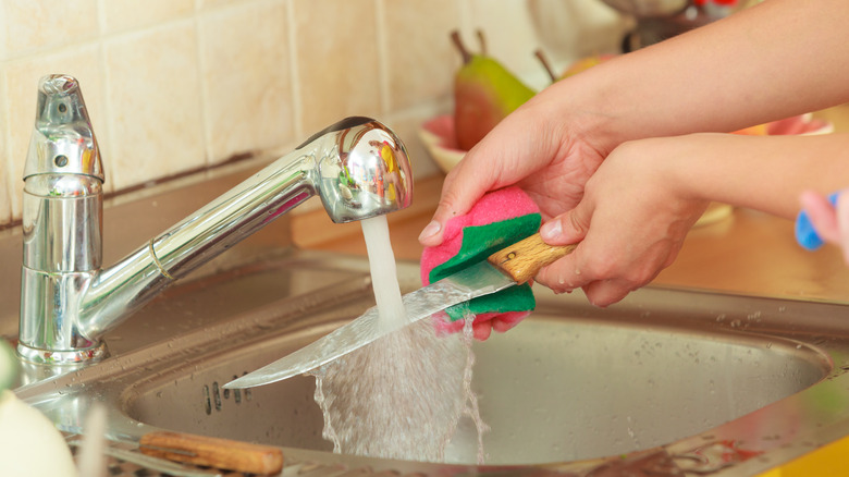 cleaning kitchen knife in the sink