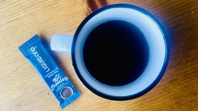 Overhead view of mug full of Liquid I.V. Hydration Multiplier Hot Chocolate with a packet alongside