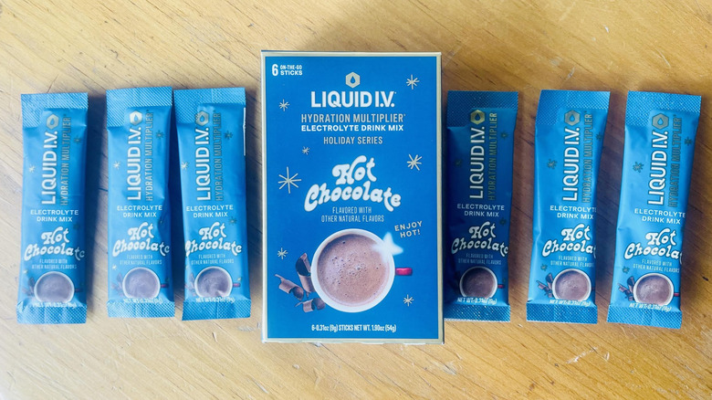 Box of Liquid I.V. Hydration Multiplier Hot Chocolate with six packets lined up on wood tabletop