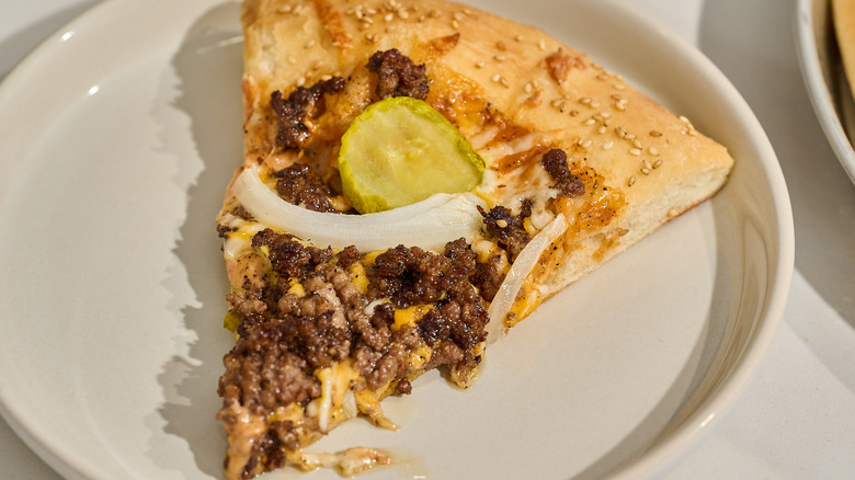 slice of cheeseburger pizza on a plate