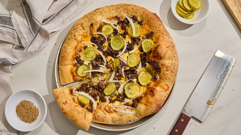 cheeseburger pizza sliced on a table