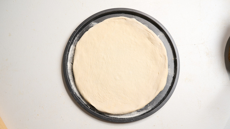 dough stretched to the size and shape of the pizza stone