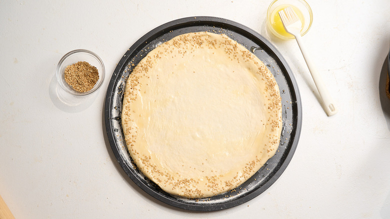 pizza crust sprinkled with sesame seed