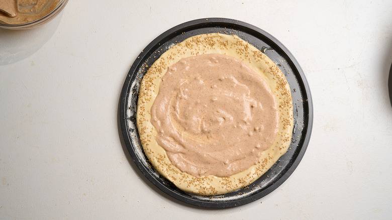 burger sauce spread across dough