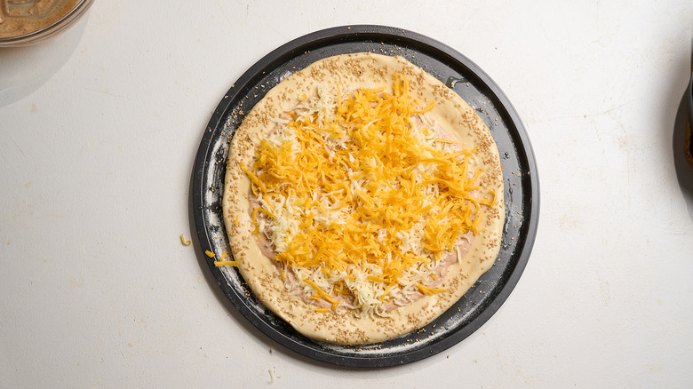 pizza dough covered in shredded cheese