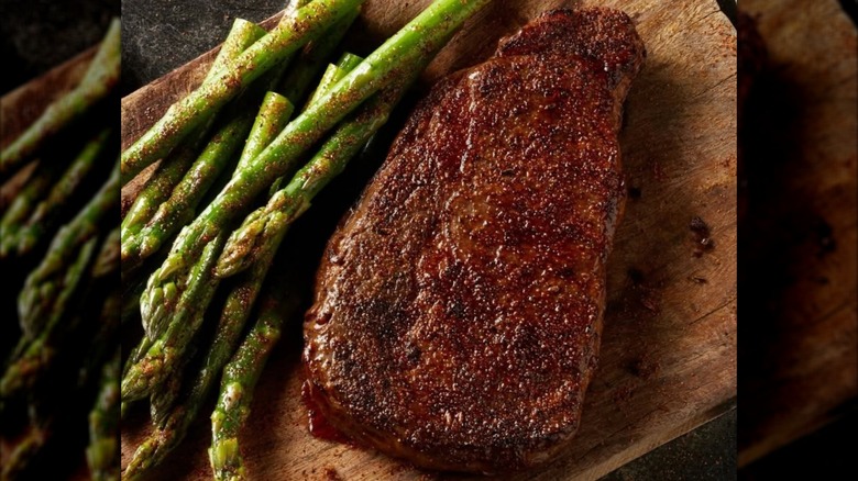 Closeup of LongHorn ribeye steak with some asparagus.
