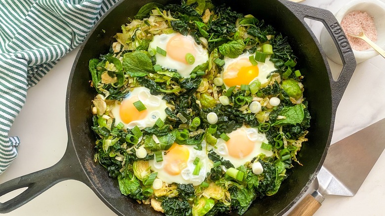 green shakshuka in cast iron skillet