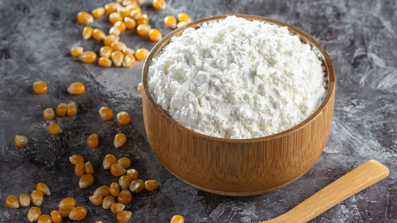A bowl of cornstarch next to corn kernels