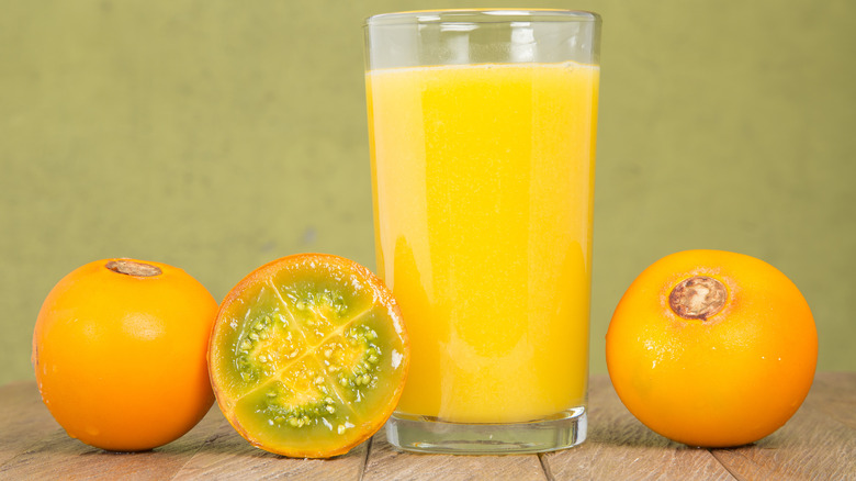Lulo fruits next to a glass of juice