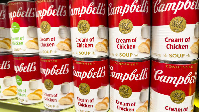 Two rows of Cambell's Cream of Chicken Soup on grocery shelves.
