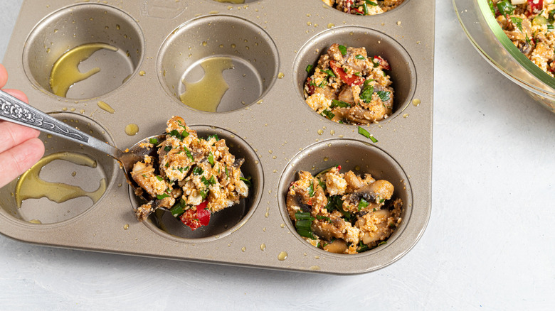 Filling a muffin pan with mushroom mixture