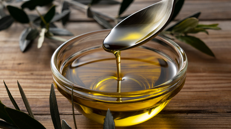 olive oil drizzling into a bowl