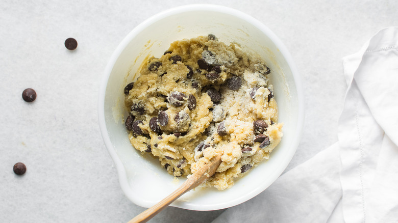 Cookie dough mixture with chocolate chips in bowl.