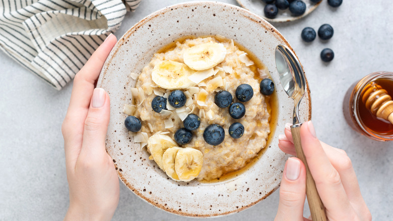 Two hands holding a bowl of oatmeal