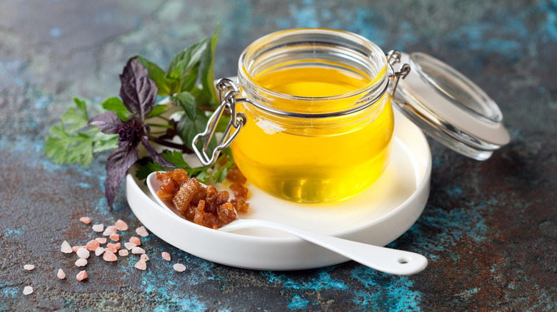 Duck fat in a jar next to various seasonings