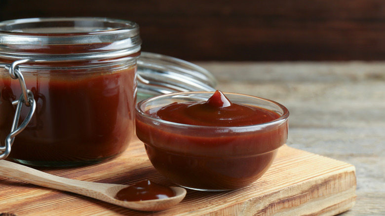Homemade barbecue sauce in a jar, then spooned out into a small bowl.