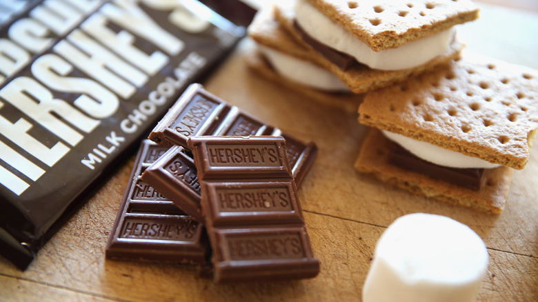 Pieces of Hershey's chocolate, a large marshmallow, and three s'mores