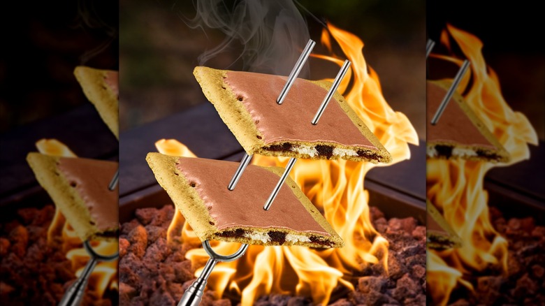 Two s'mores flavor Pop-Tarts on skewers over a fire
