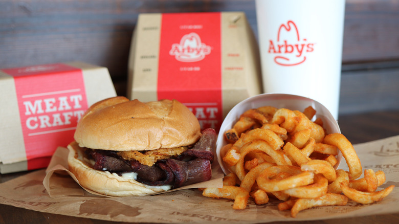 A meaty Arby's sandwich, curly fries, and a soft drink.