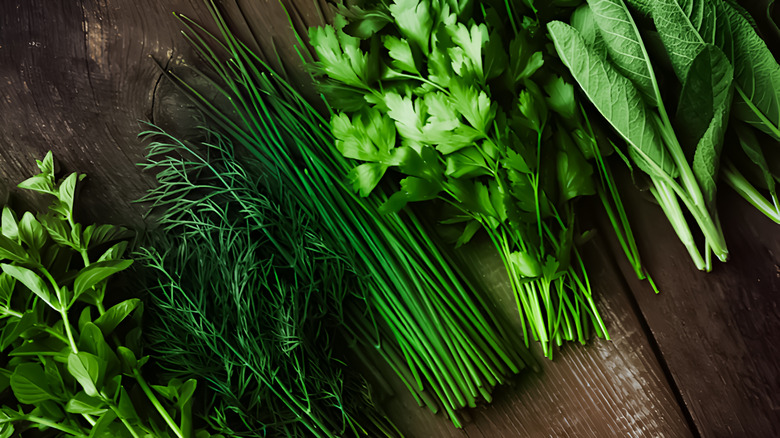 a selection of fresh green herbs on a wood background