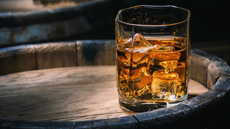 Glass of bourbon on a barrel