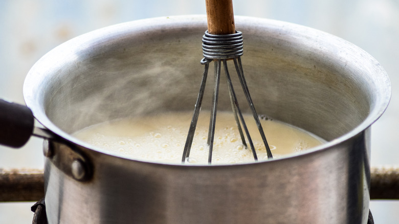 Whisking milk in a pan on the stove