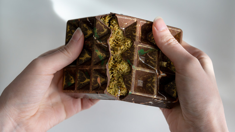 A person is splitting a Dubai chocolate bar
