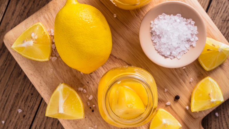 Lemons and salt on wooden cutting board