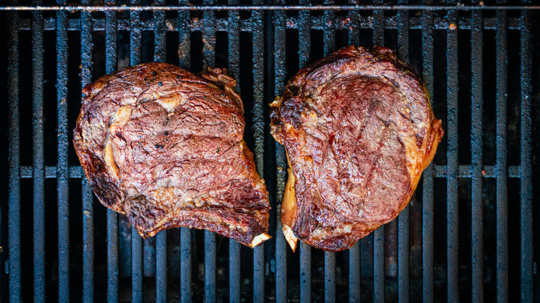 Bone-in ribeyes on a grill.