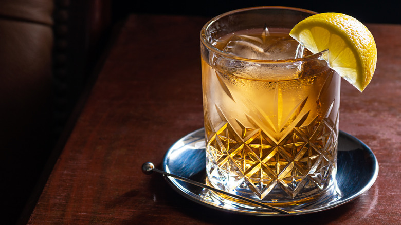 Whiskey cocktail in a glass garnished with a slice of lemon