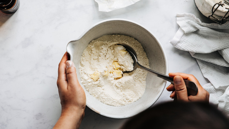 Butter cubes being mixed into a pie dough