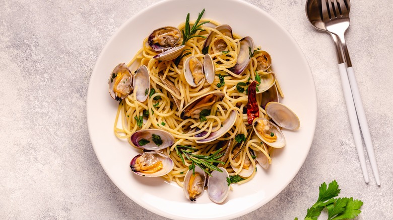 clam spaghetti with parsley and rosemary garnish