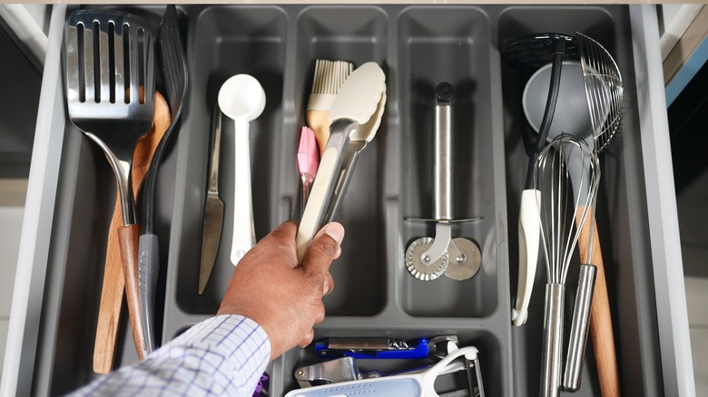 Hang extracting utensil from organized kitchen drawer