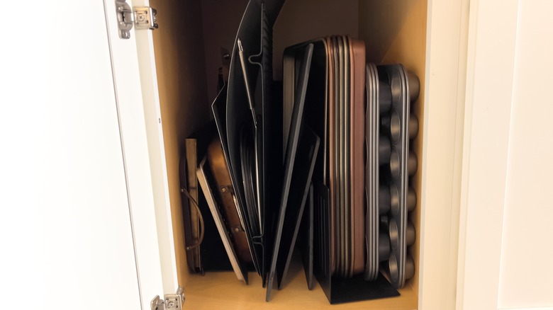 Baking trays stored upright in cabinet using dividers
