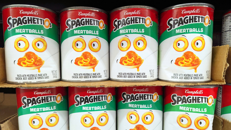 Cans of Campbell's SpaghettiOs stacked on a store shelf