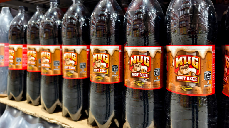 Lined up Mug Root Beer bottles on a store shelf