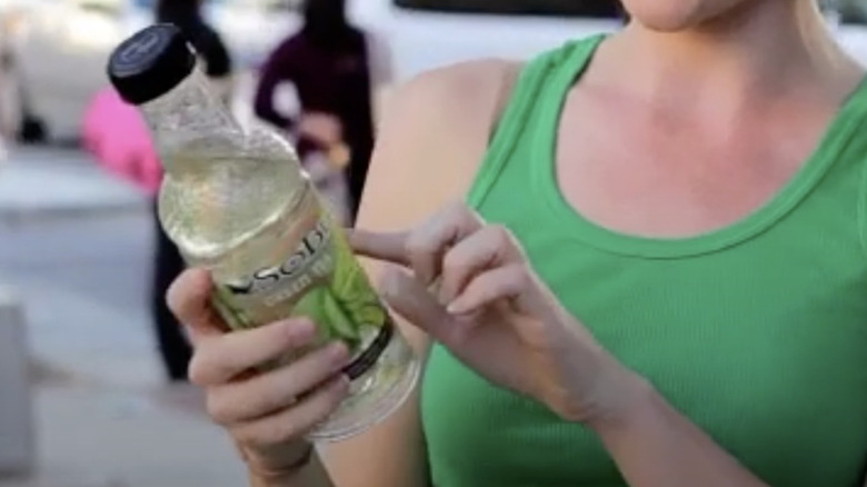 Woman inspects bottle of SoBe Green Tea