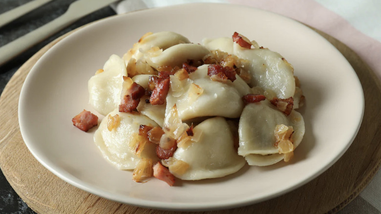 Crispy bacon and onions atop a plate of pierogies