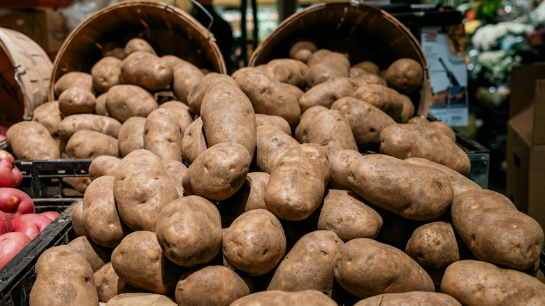 Pile of potatoes spilling out of baskets at a market